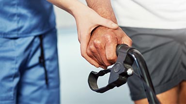 person assisting someone in a rehab walker