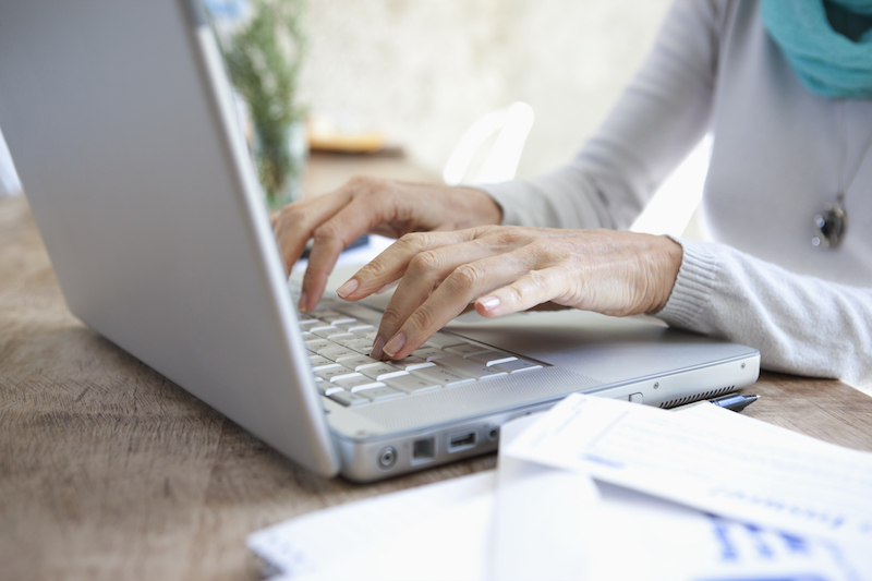 Woman's hands typing on a silver laptop