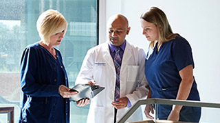 A healthcare team discusses a document together.