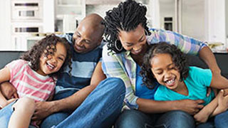 A joyful family laughing together on a couch.