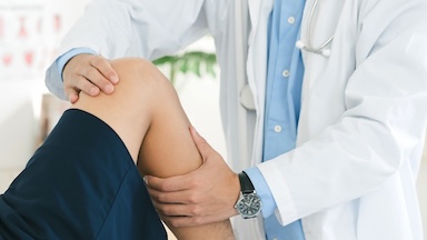 A doctor examines a patient's knee