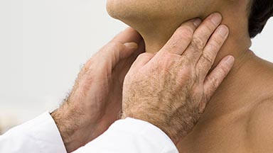 A healthcare professional's hands gently examining a patient's neck.