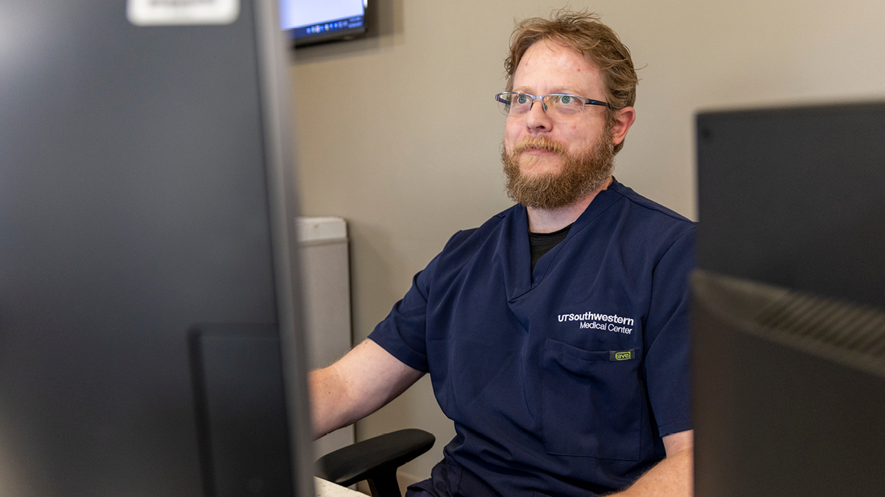 Male nurses with glasses sitting at desk